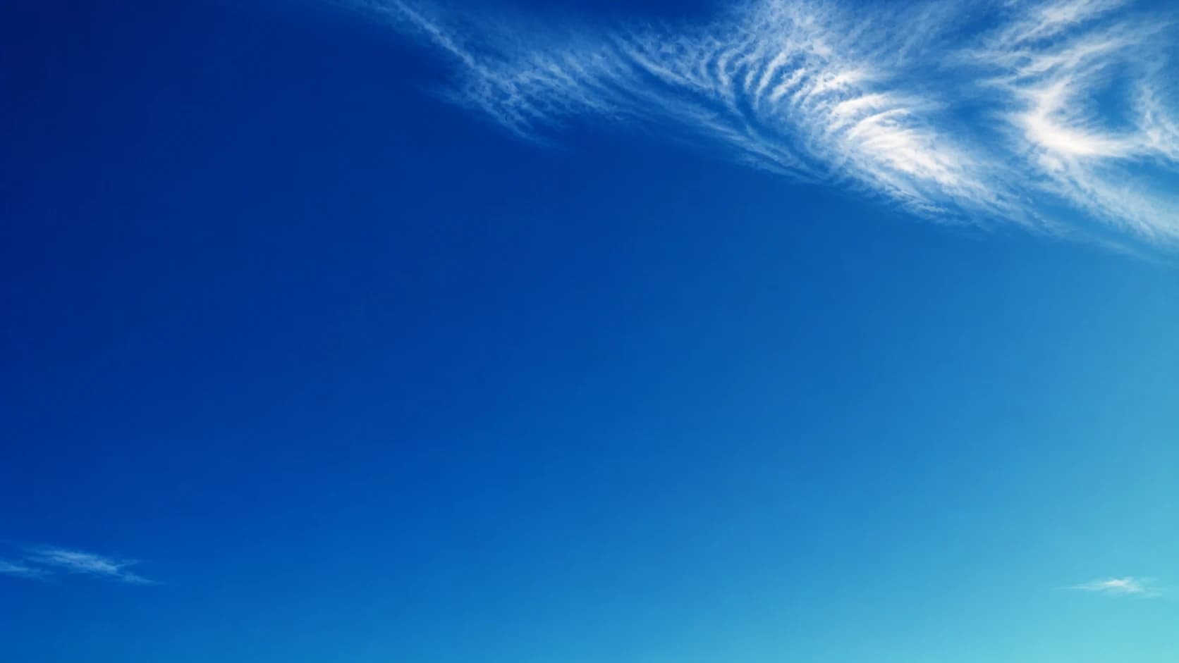 Soft white clouds drifting across a blue sky